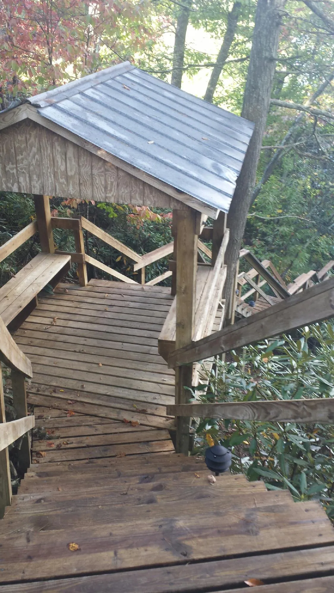 Metal roofed shelter over wooden steps on a wooded walkway — Skylight Repair & Installation work by our crew in Shirley