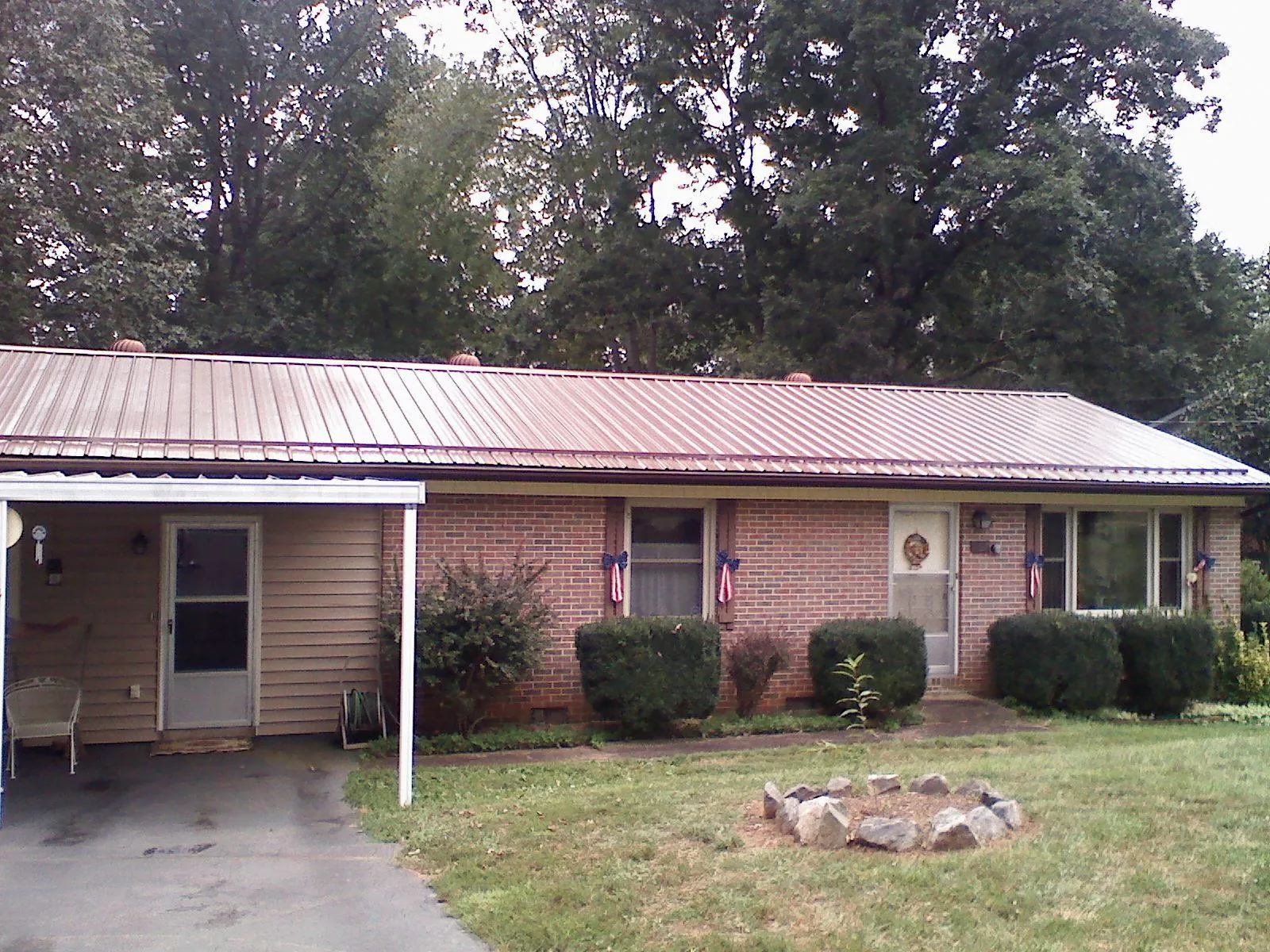 Bronze metal roof and carport on a brick ranch home — Roof Repair work by our crew in Shirley